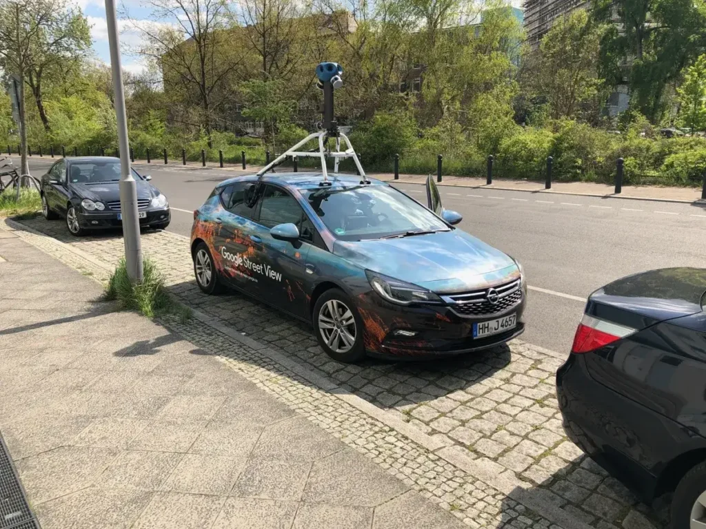 A Google Street View car with a roof-mounted camera parked on a street in Berlin