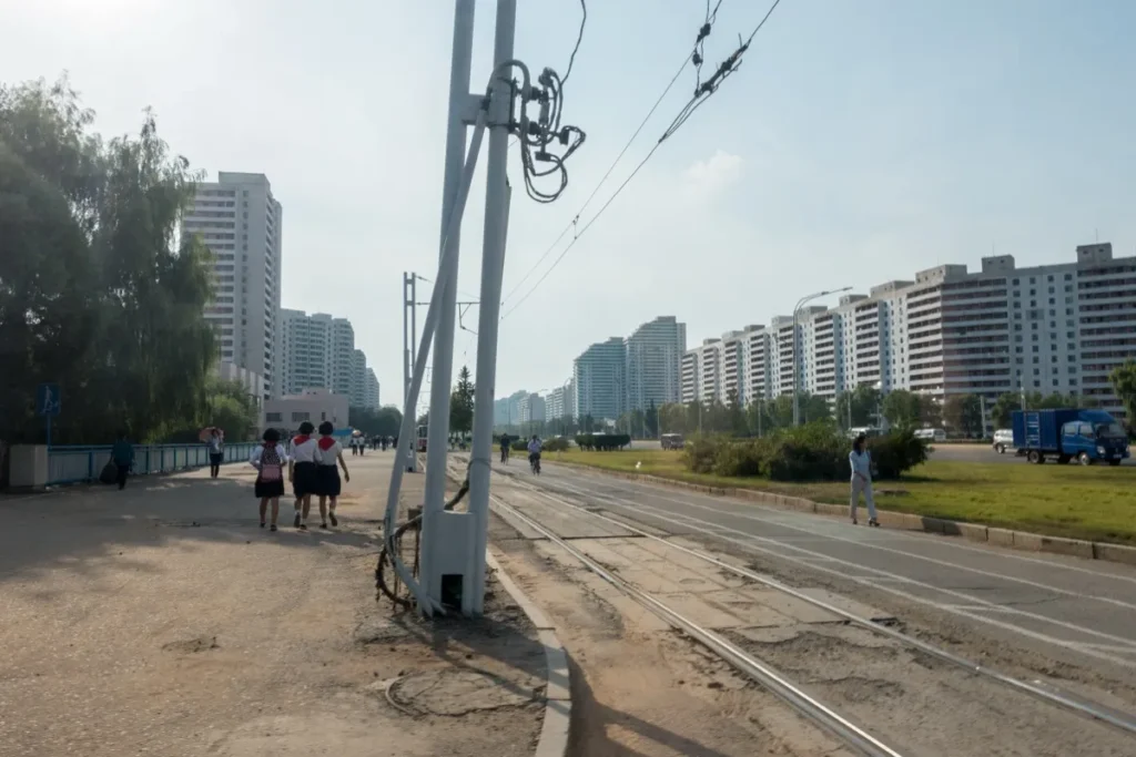 A wide street lined with tall apartment blocks in Pyongyang, North Korea, a capital with no Google Street View imagery